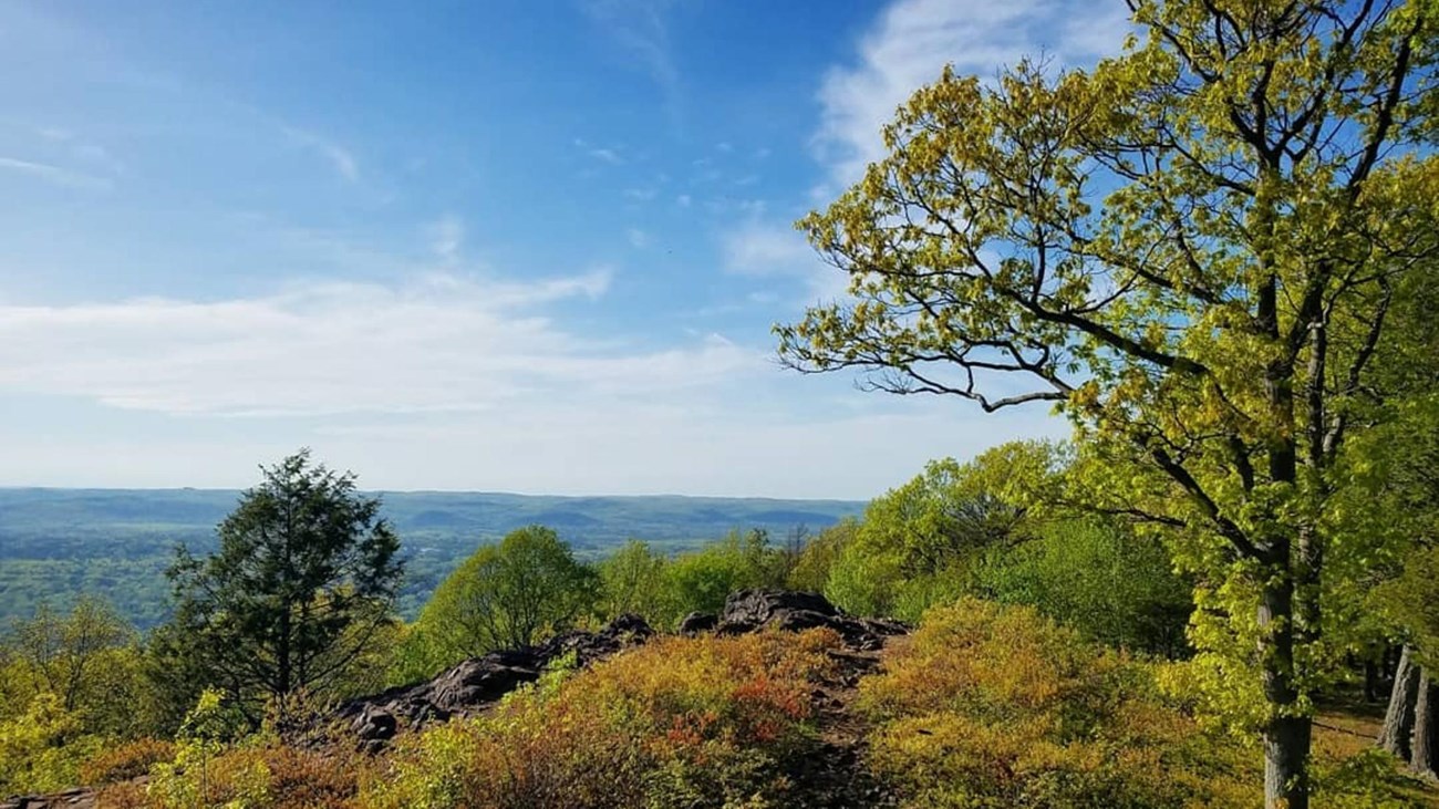 Faint trail along a ridgeline with scenic overlook off to the left